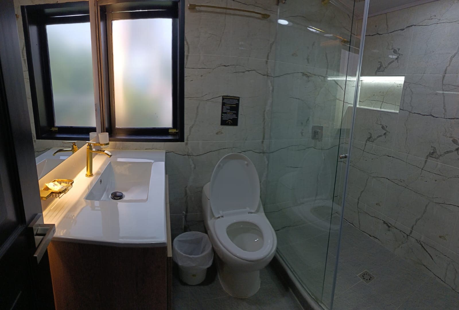 Baño en mármol con grifería dorada